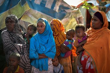 A group of Somali women stand near a water point at the Dayniile IDP camp