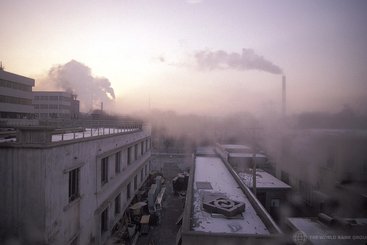 View of rooftops and smokestacks, China.