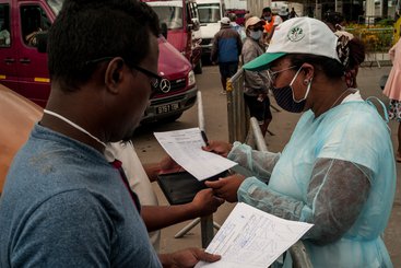 Health and Land Transport Agency (ATT) staff check passenger lists at Andohatapenaka Bus Station, Madagascar