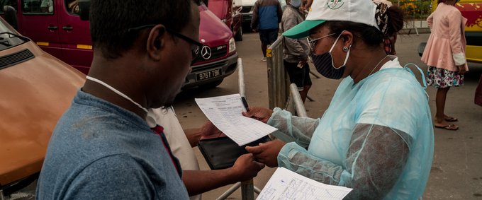 Health and Land Transport Agency (ATT) staff check passenger lists at Andohatapenaka Bus Station, Madagascar