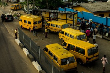 Yellow buses congregating at a busy bus stop in Lagos, Nigeria. 2018.