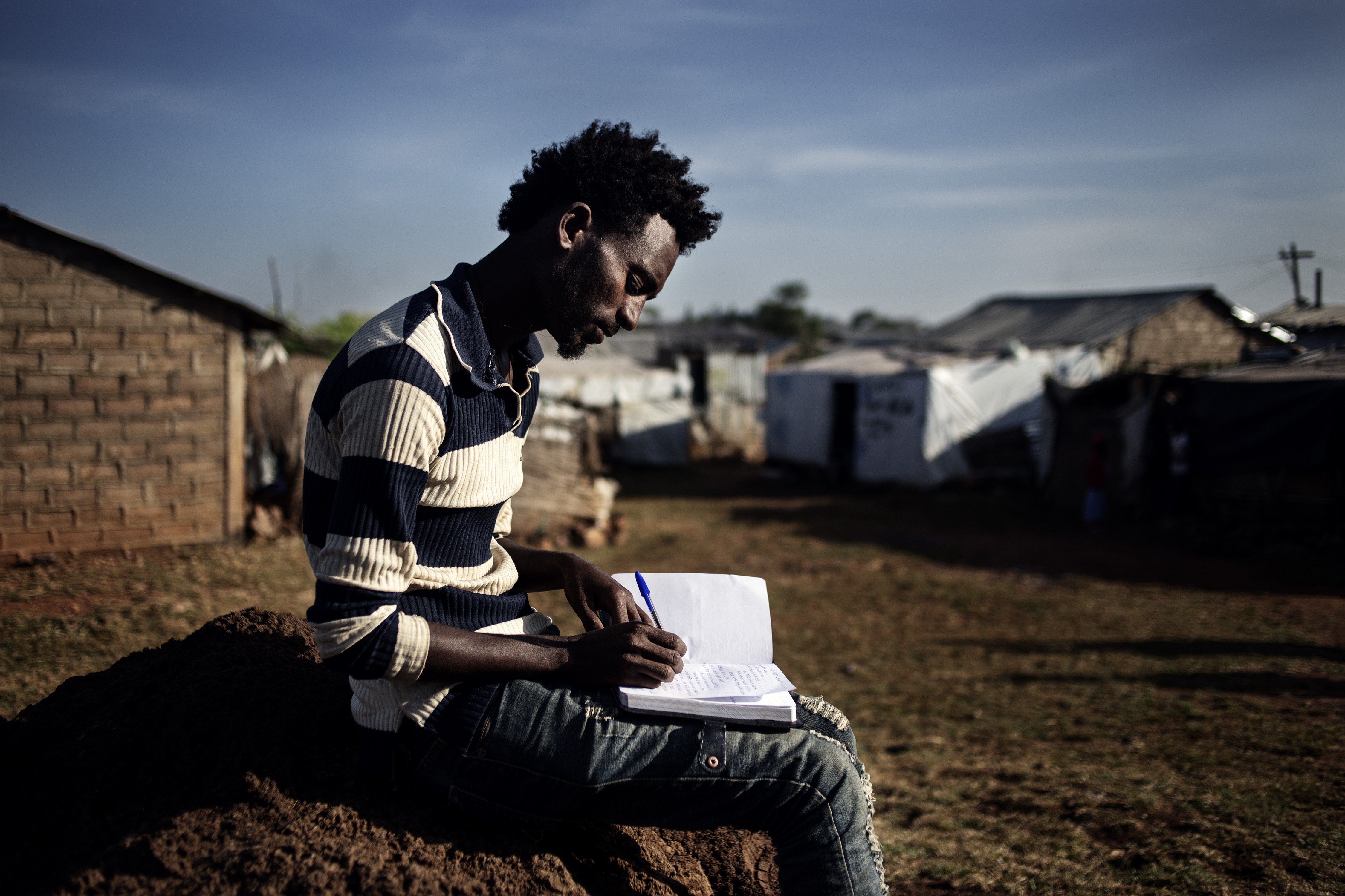 Tesfay, 24, writing poetry and short stories in the Adi Harush refugee camp, Ethiopia.