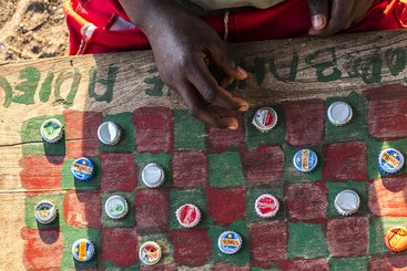 Burundian refugees play checkers at Kamvivira transit centre, DRC