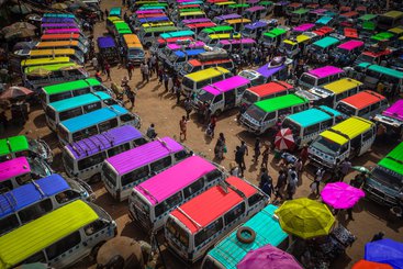 Multi-coloured vans in a depot in Kampala, Uganda. 2020.