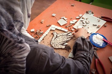 refugee woman creating mosaic