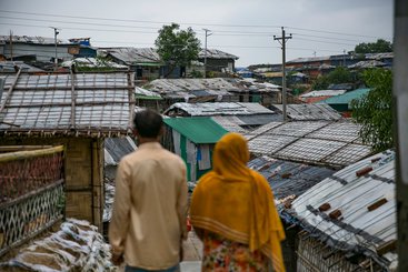 A Rohingya couple pose for a photo in Balukhali camp outside their home.