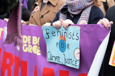 Woman marching and holding a sign saying Feminists for climate justice ©ElenaBaryshnikova | Shutterstock ID:1667268439